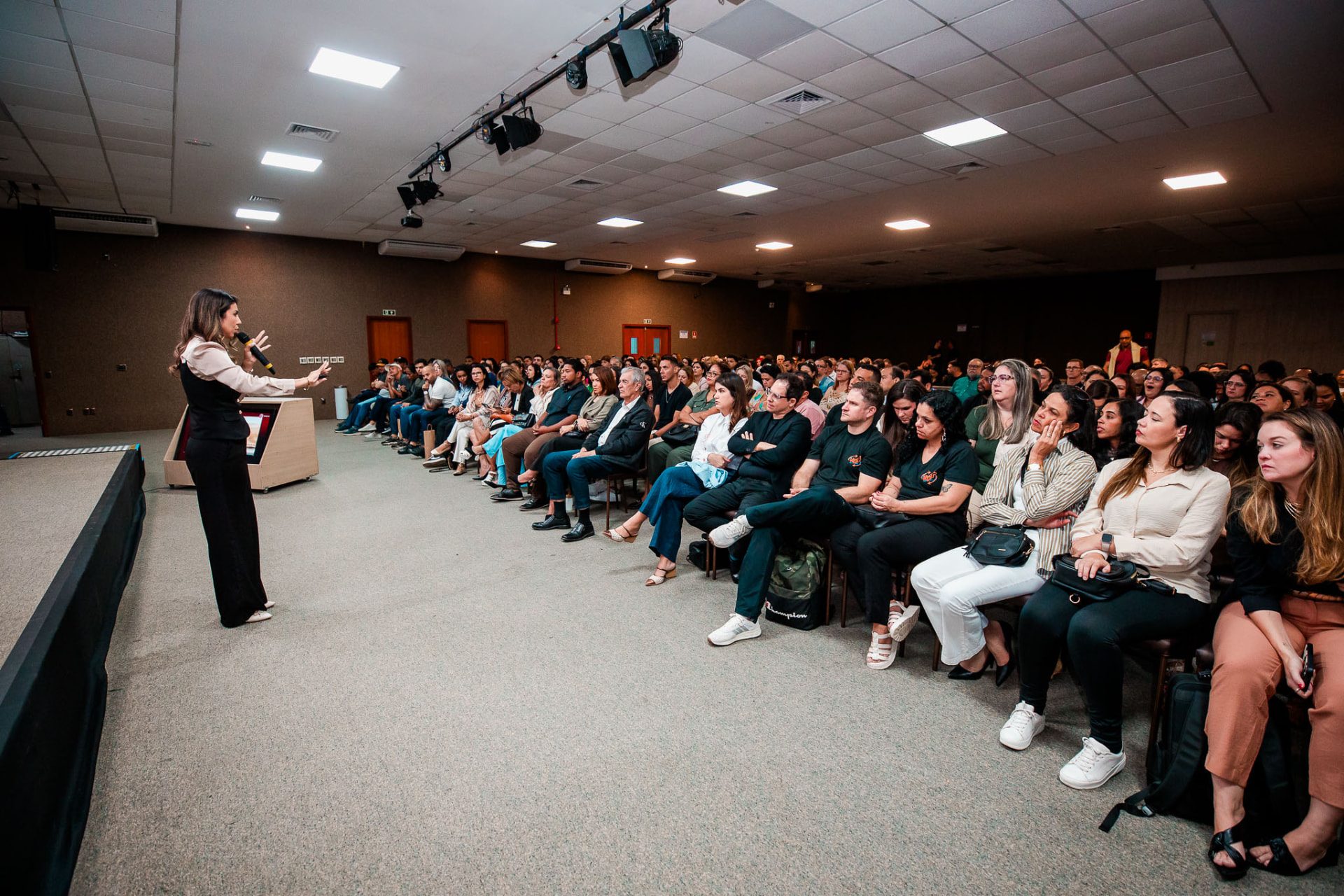 Plateia com luzes de celular durante a palestra