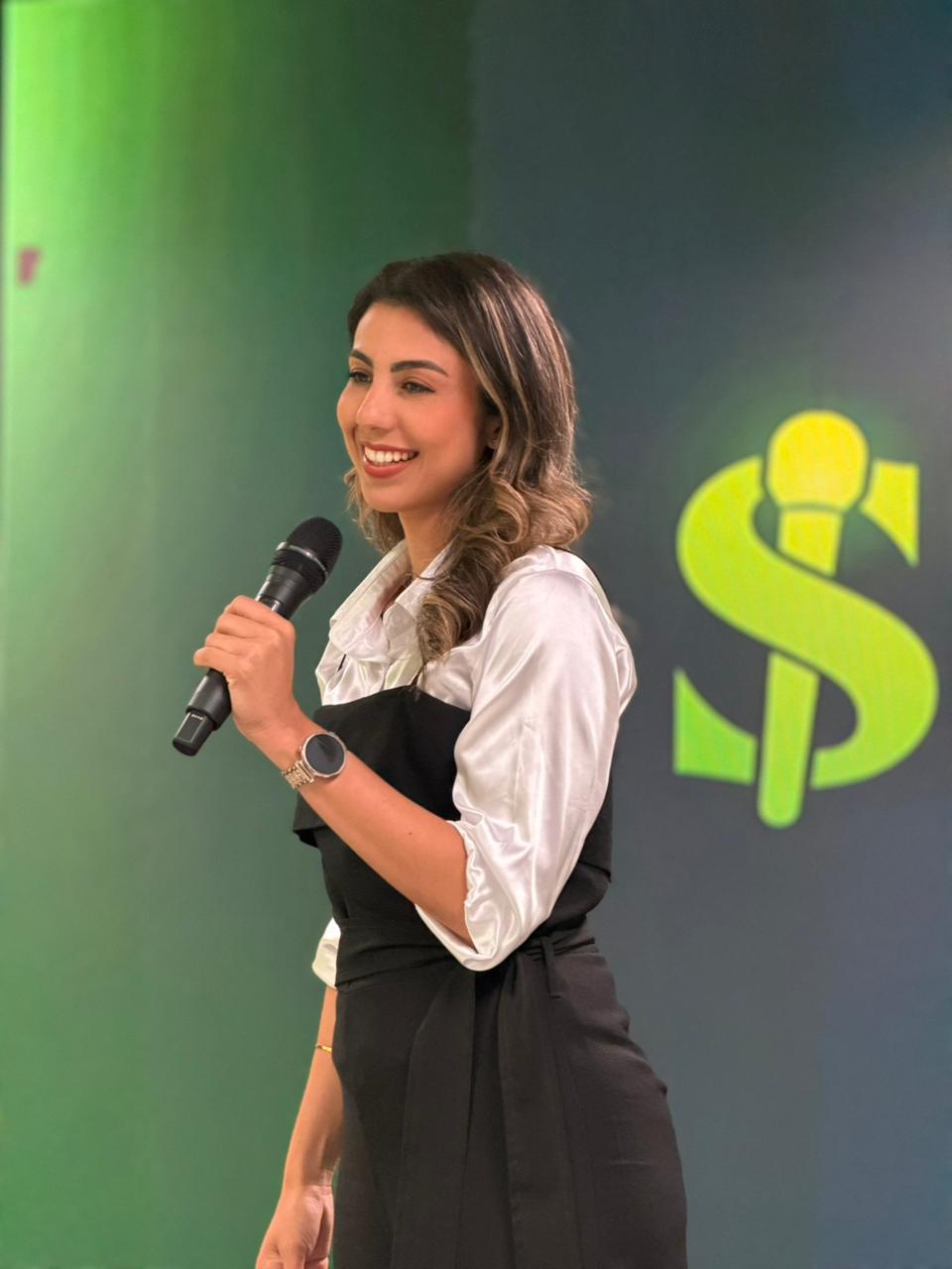 Thádile Thays Aguiar com microfone em cena