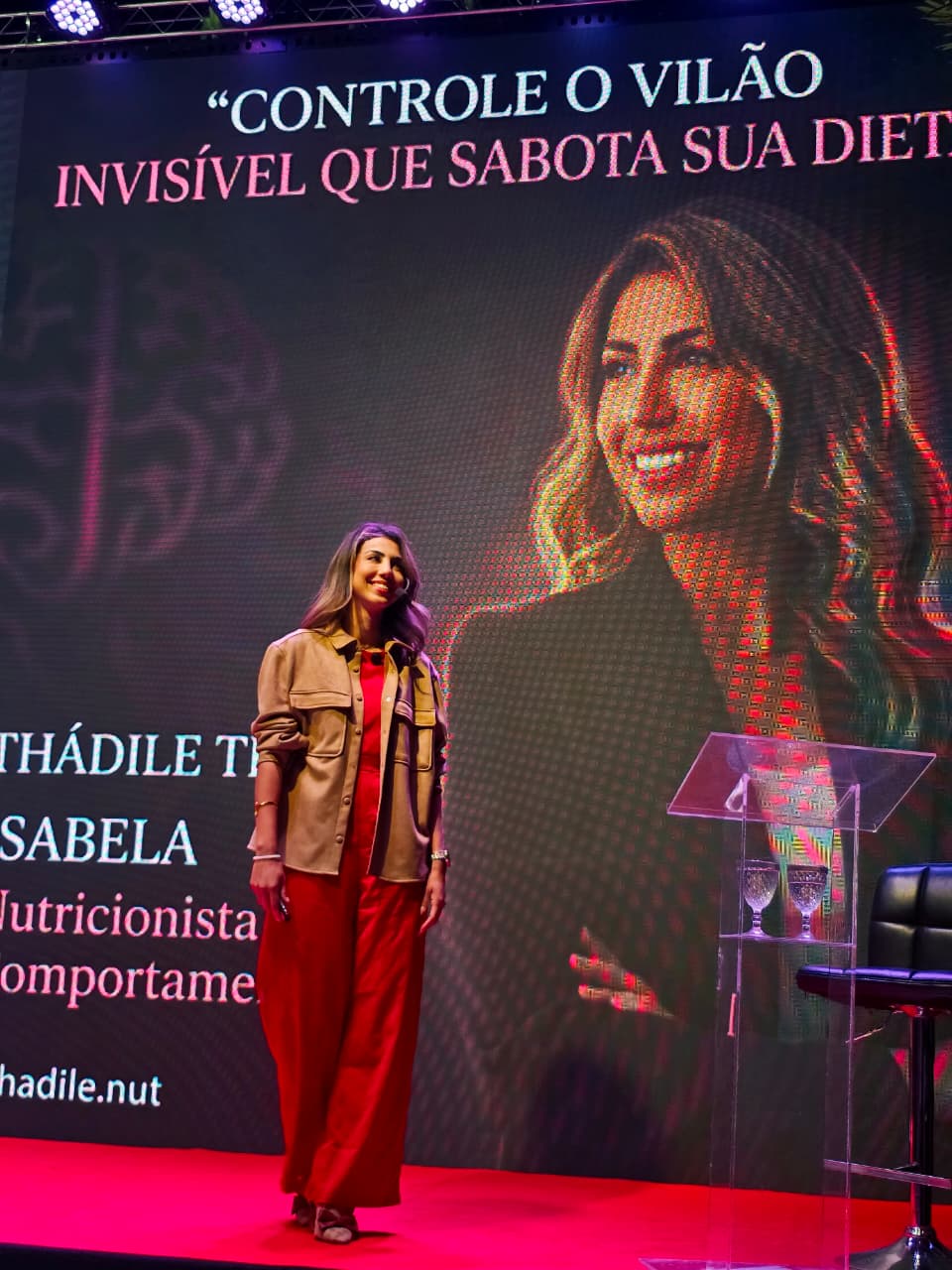 Thádile Thays Aguiar no palco em frente ao telão
